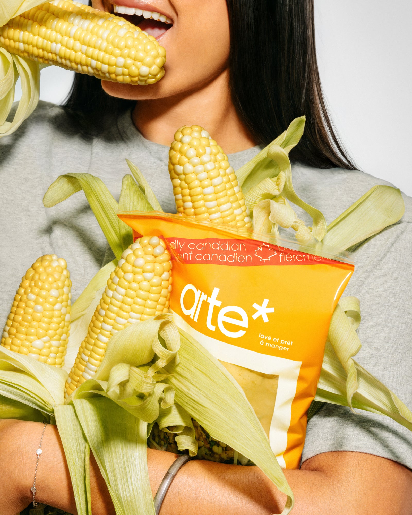 woman eating corn and holding arte cajun honey ranch