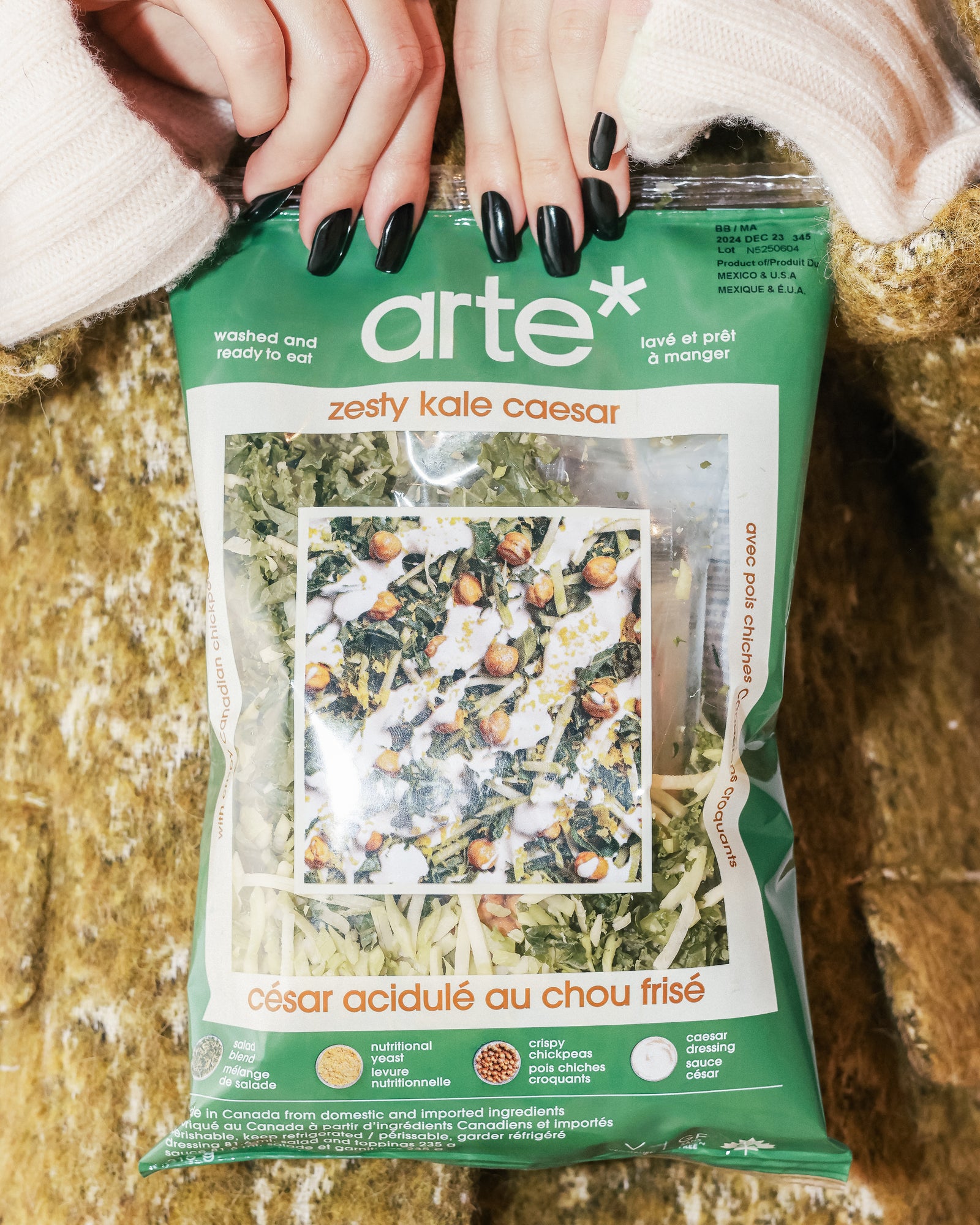 hands holding arte zesty kale Caesar salad