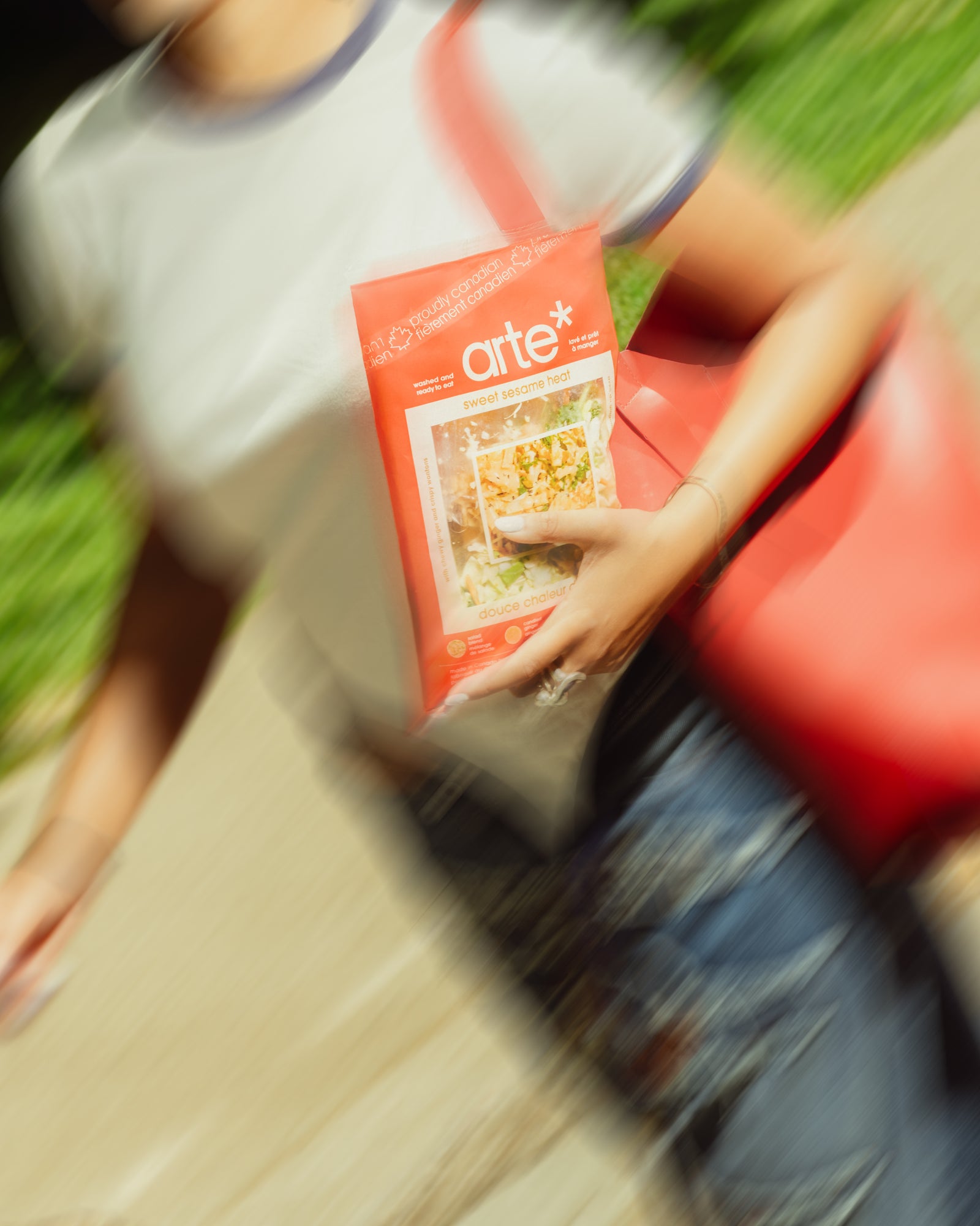 woman running holding arte sweet sesame heat salad